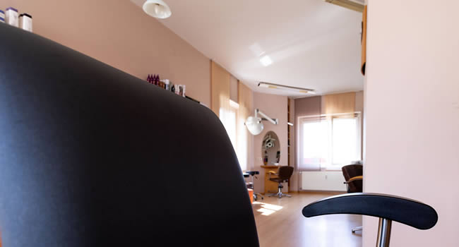 Stilischtes Foto eines Friseursessels und kleiner Auschnitt des Salons.